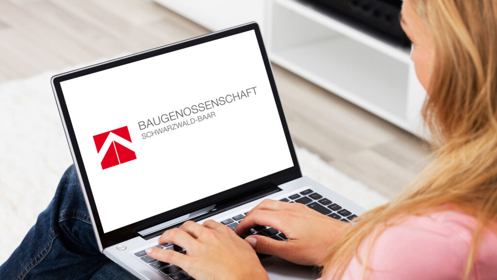 Frau am Laptop - Auf dem Bildschirm ist das BG Baar Logo zu sehen